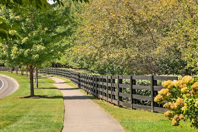 view of community with a lawn and fence
