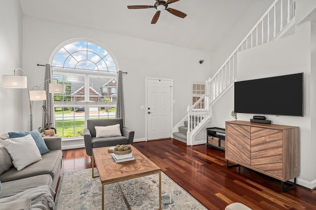 living area featuring ceiling fan, wood finished floors, stairway, and high vaulted ceiling