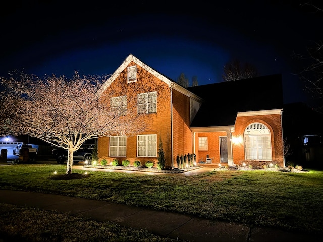traditional-style house with a yard and brick siding