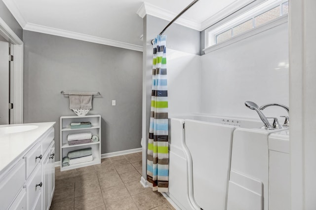 bathroom with tile patterned flooring, ornamental molding, a bathtub, and vanity