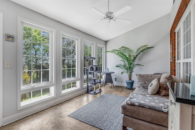 living area featuring baseboards and ceiling fan