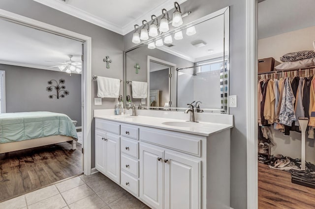 full bath featuring crown molding, double vanity, ceiling fan, connected bathroom, and a spacious closet