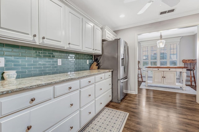 kitchen with crown molding, white cabinets, and visible vents