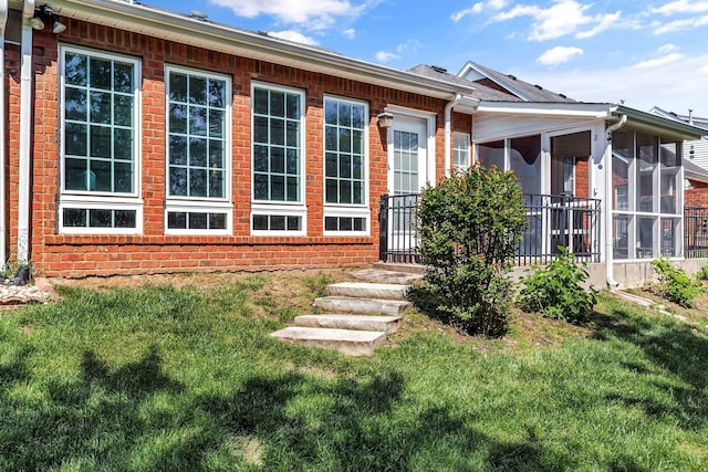 back of house with a sunroom and a yard