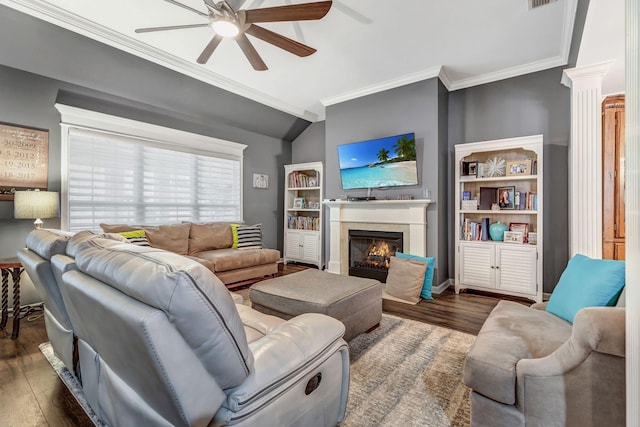 living area featuring crown molding, ceiling fan, wood finished floors, and a lit fireplace