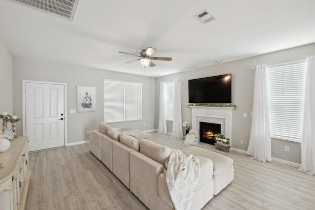 living room featuring visible vents, a ceiling fan, and light wood-type flooring