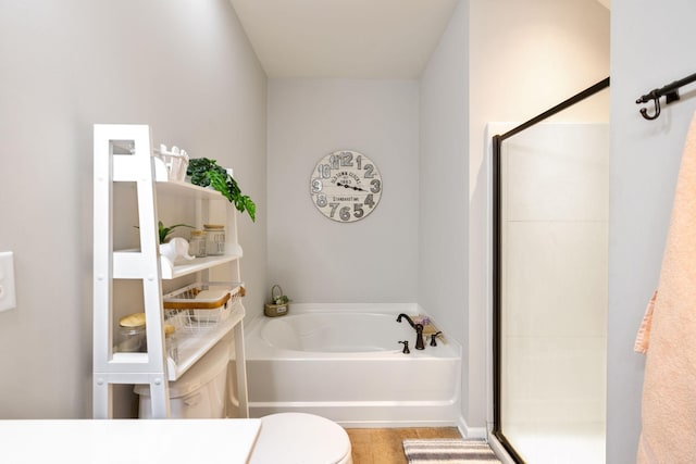bathroom featuring toilet, a shower stall, and a bath