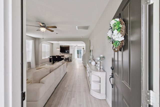 entrance foyer featuring visible vents, arched walkways, ceiling fan, and a healthy amount of sunlight
