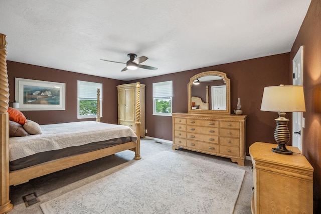 carpeted bedroom with baseboards, a ceiling fan, and visible vents