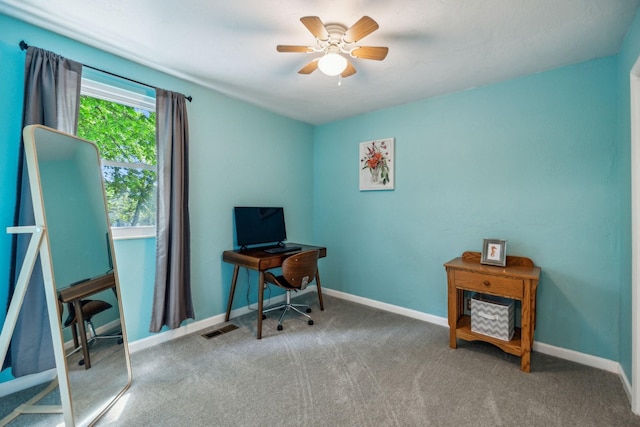 carpeted home office with a ceiling fan, baseboards, and visible vents