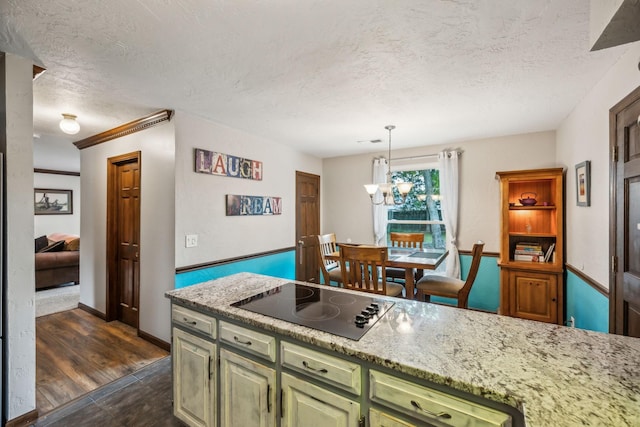 kitchen featuring black electric cooktop, green cabinetry, pendant lighting, and a textured ceiling