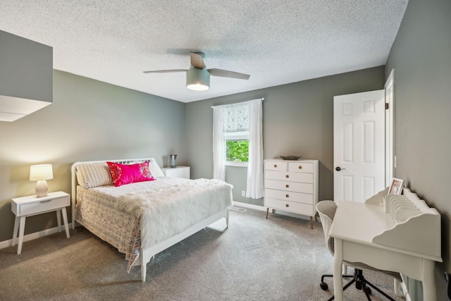 carpeted bedroom featuring baseboards, a ceiling fan, and a textured ceiling