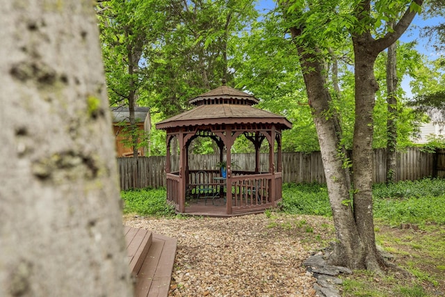 view of property's community featuring a deck, a gazebo, and a fenced backyard
