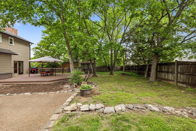 view of yard with outdoor dining area, a fenced backyard, and a wooden deck