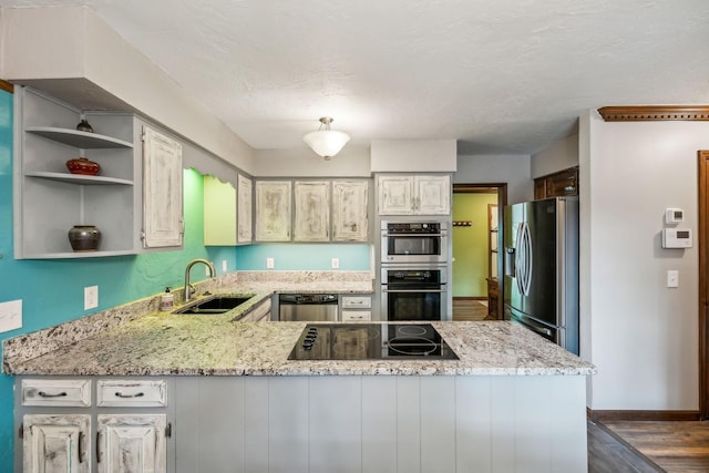 kitchen featuring open shelves, a sink, stainless steel appliances, a peninsula, and dark wood-style floors