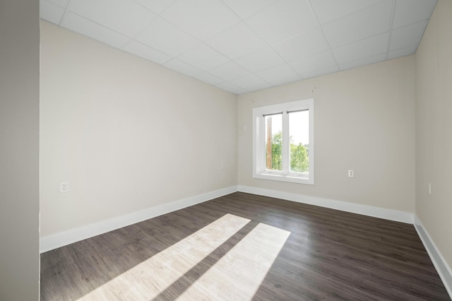 231 Wolf Ridge Ln, Lynchburg, TN 37352 - spare room featuring baseboards, dark wood-style flooring, and a paneled ceiling