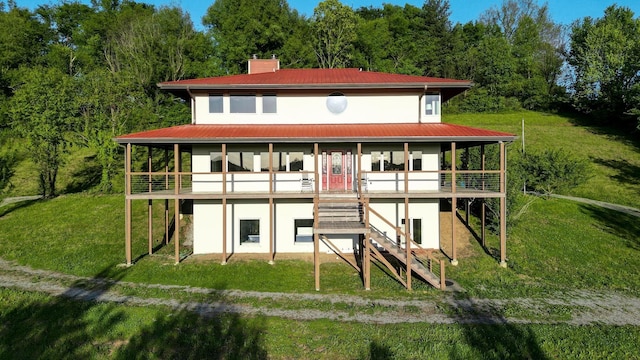 231 Wolf Ridge Ln, Lynchburg, TN 37352 - rear view of property with stucco siding, a yard, and a chimney