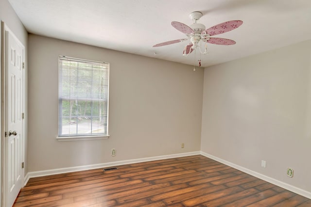 empty room with baseboards, wood finished floors, a healthy amount of sunlight, and visible vents