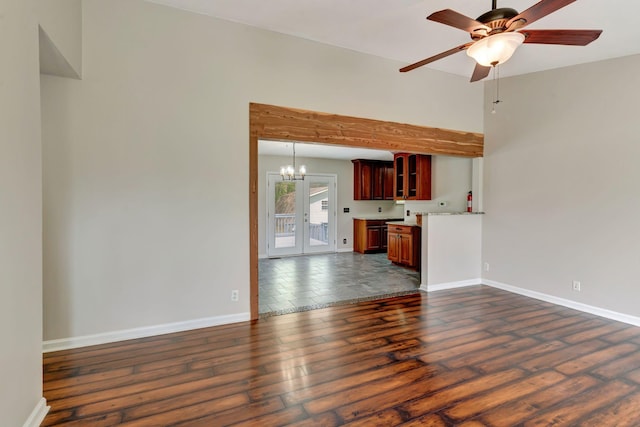 unfurnished living room featuring baseboards, ceiling fan with notable chandelier, and dark wood-style flooring