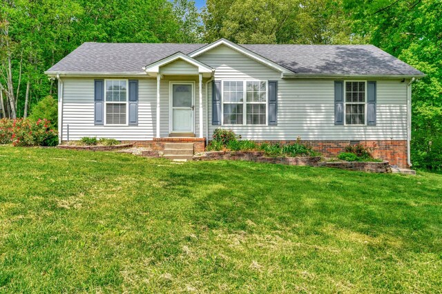 view of front of house featuring a shingled roof and a front yard