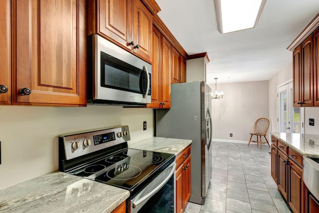 kitchen featuring light stone countertops, stainless steel appliances, brown cabinetry, and a notable chandelier