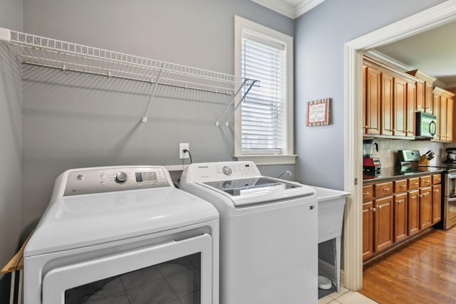 5028 Burke Trl, Nolensville, TN 37135 - clothes washing area with ornamental molding, laundry area, washing machine and dryer, and light wood-style flooring