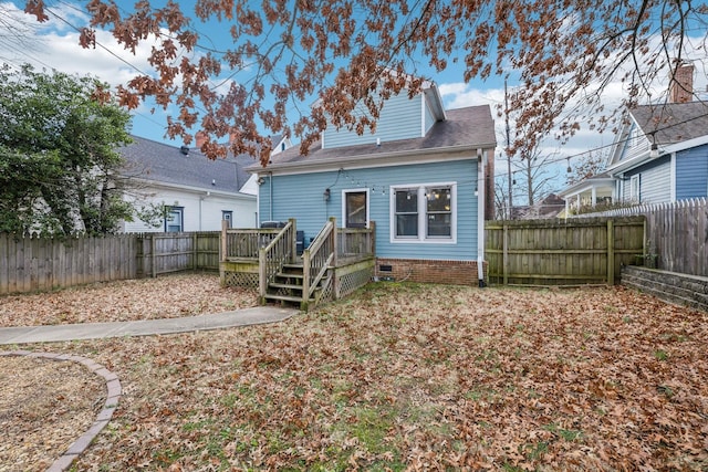 back of property with a fenced backyard, a shingled roof, and a deck