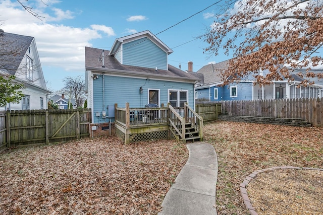 back of house featuring a wooden deck, a fenced backyard, and roof with shingles