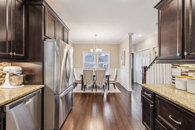 kitchen with backsplash, dark brown cabinets, light stone counters, a notable chandelier, and stainless steel appliances
