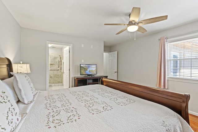 bedroom with baseboards, ensuite bathroom, a ceiling fan, and wood finished floors