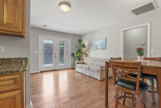 living area featuring visible vents, french doors, and light wood-style floors