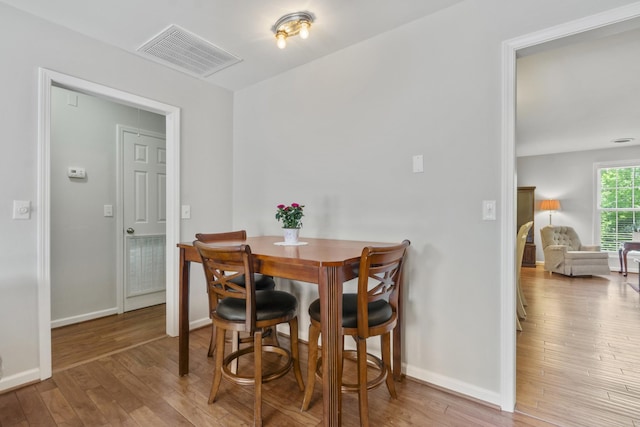 dining room featuring wood-type flooring, baseboards, and visible vents