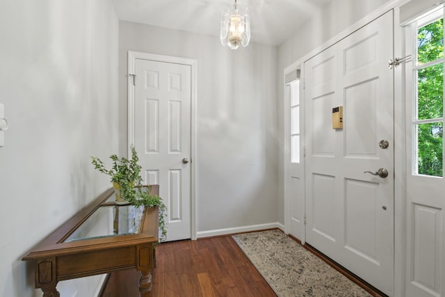 foyer with dark wood-style flooring and baseboards