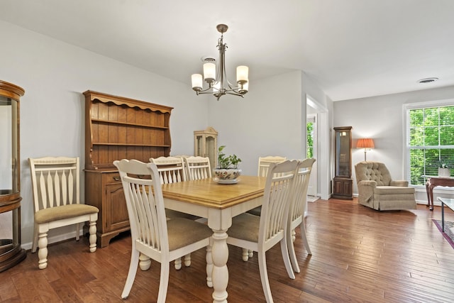 dining area featuring an inviting chandelier, dark wood-type flooring, and visible vents