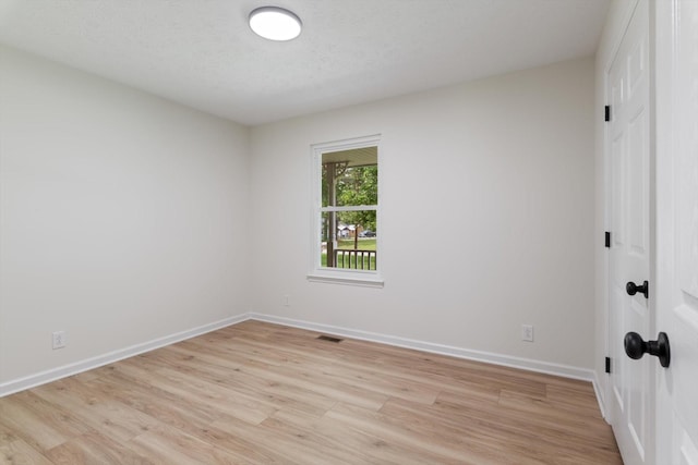 unfurnished room with baseboards, visible vents, and light wood-style floors
