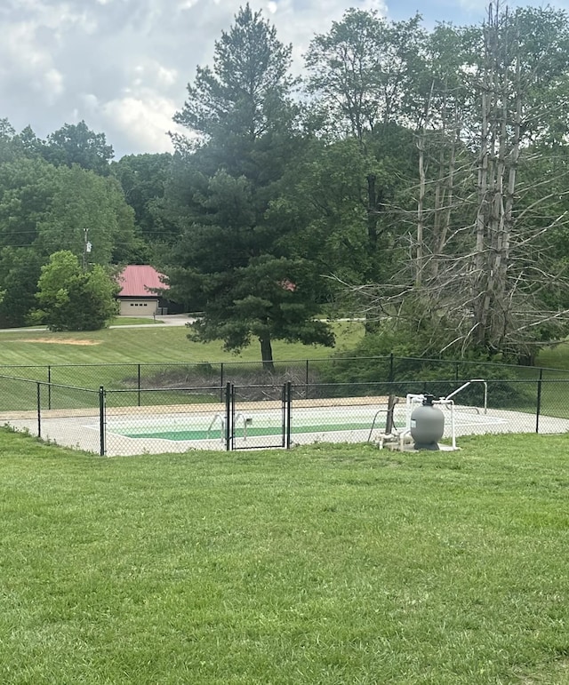 view of property's community featuring a lawn and fence