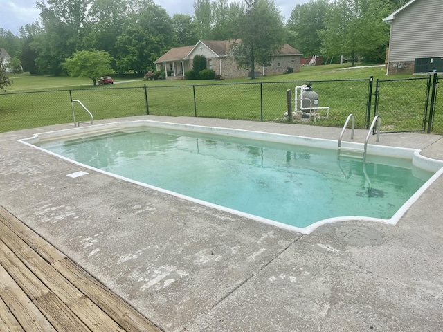 view of pool featuring a lawn, fence, and a fenced in pool