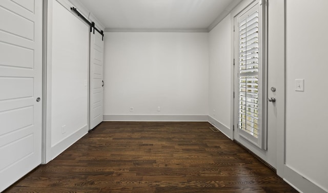 802 Montrose Ave, Nashville, TN 37204 - unfurnished bedroom featuring baseboards, a barn door, dark wood-style flooring, and ornamental molding