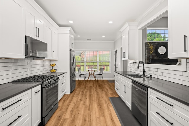 1006 Grider Dr, Gallatin, TN 37066 - kitchen featuring black appliances, dark countertops, a sink, ornamental molding, and white cabinetry