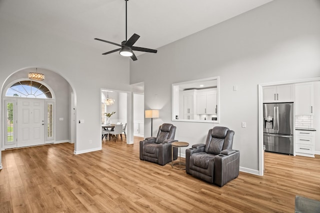 1006 Grider Dr, Gallatin, TN 37066 - living area featuring a towering ceiling, a chandelier, light wood finished floors, arched walkways, and baseboards