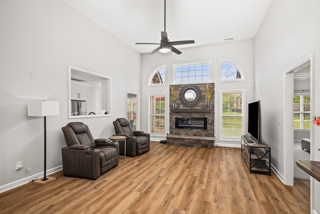 1006 Grider Dr, Gallatin, TN 37066 - living room featuring light wood-type flooring, a fireplace, a ceiling fan, plenty of natural light, and a high ceiling
