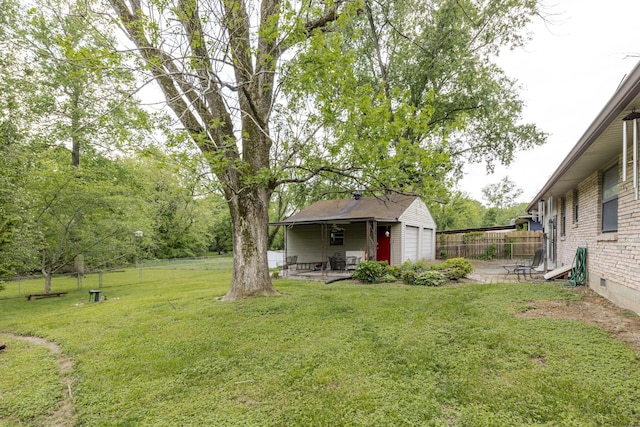 view of yard with fence, an outbuilding, and a patio area