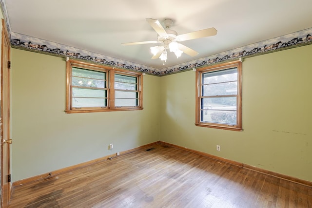 unfurnished room featuring baseboards, ceiling fan, a wealth of natural light, and light wood-type flooring