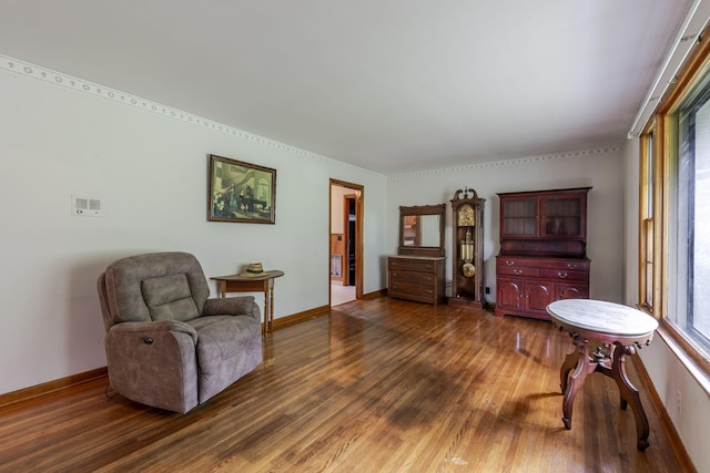 living area featuring baseboards and dark wood finished floors