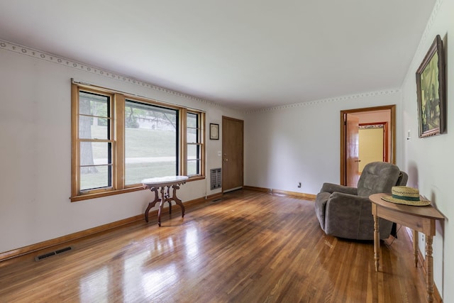 sitting room featuring baseboards, visible vents, and wood finished floors