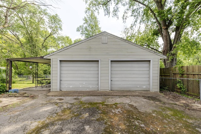 garage with fence and a detached garage