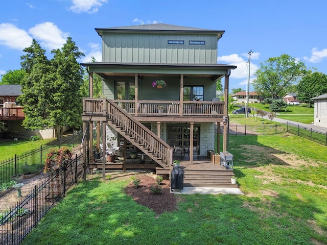 rear view of property with board and batten siding, a deck, stairway, a fenced backyard, and a yard