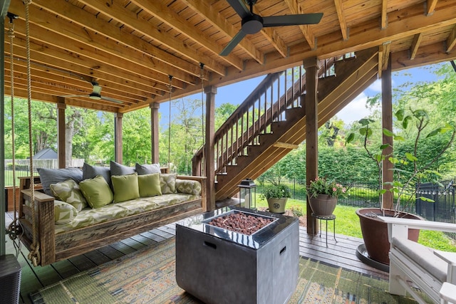 view of patio with fence, an outdoor living space with a fire pit, a wooden deck, stairway, and a ceiling fan