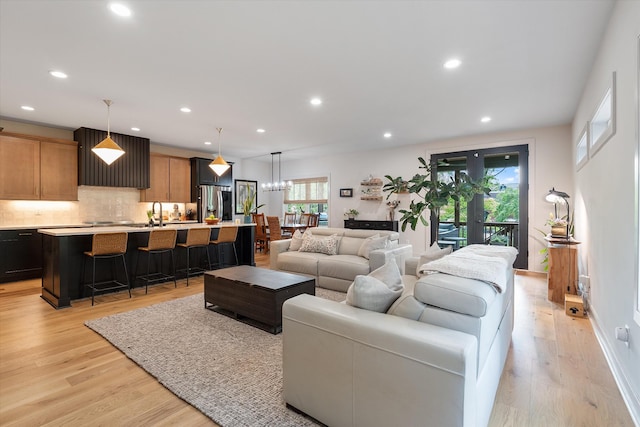 living area featuring recessed lighting, baseboards, and light wood-type flooring