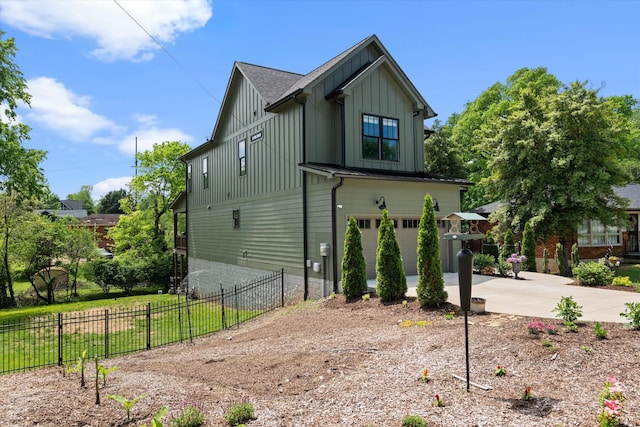 view of property exterior featuring fence, board and batten siding, an attached garage, and driveway